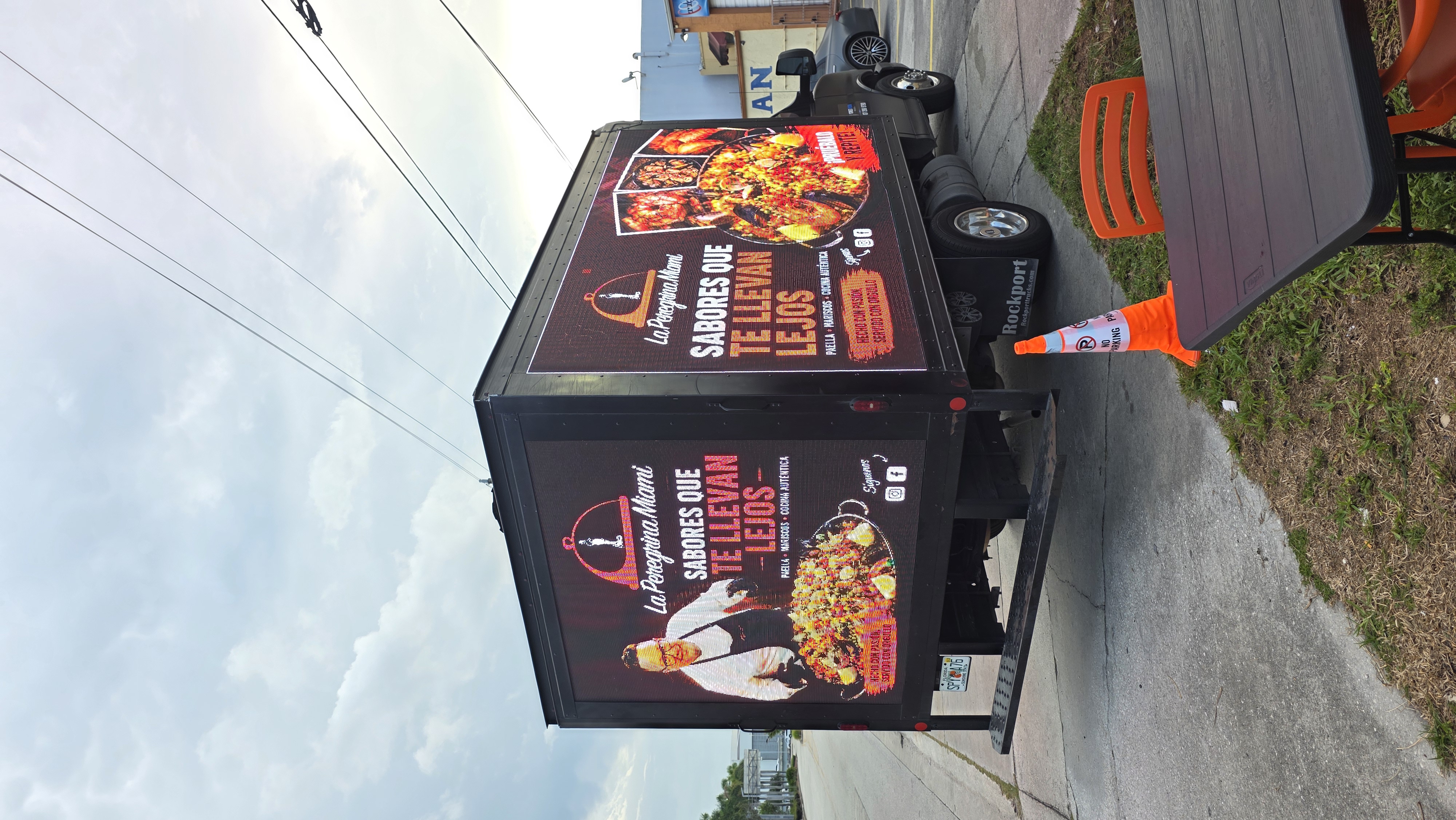Full view of the truck displaying La Peregrina Miami's food campaign on its side and rear LED screens